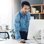 Healthcare, man doctor and computer research, healthcare innovation or planning online. Medical wor.
